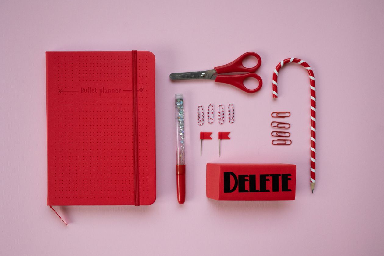Back to school supplies including notebooks and pencils on a pink background