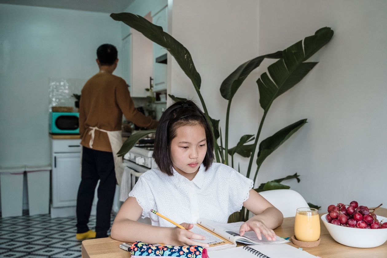 Girl doing her writing at the kitchen table at home
